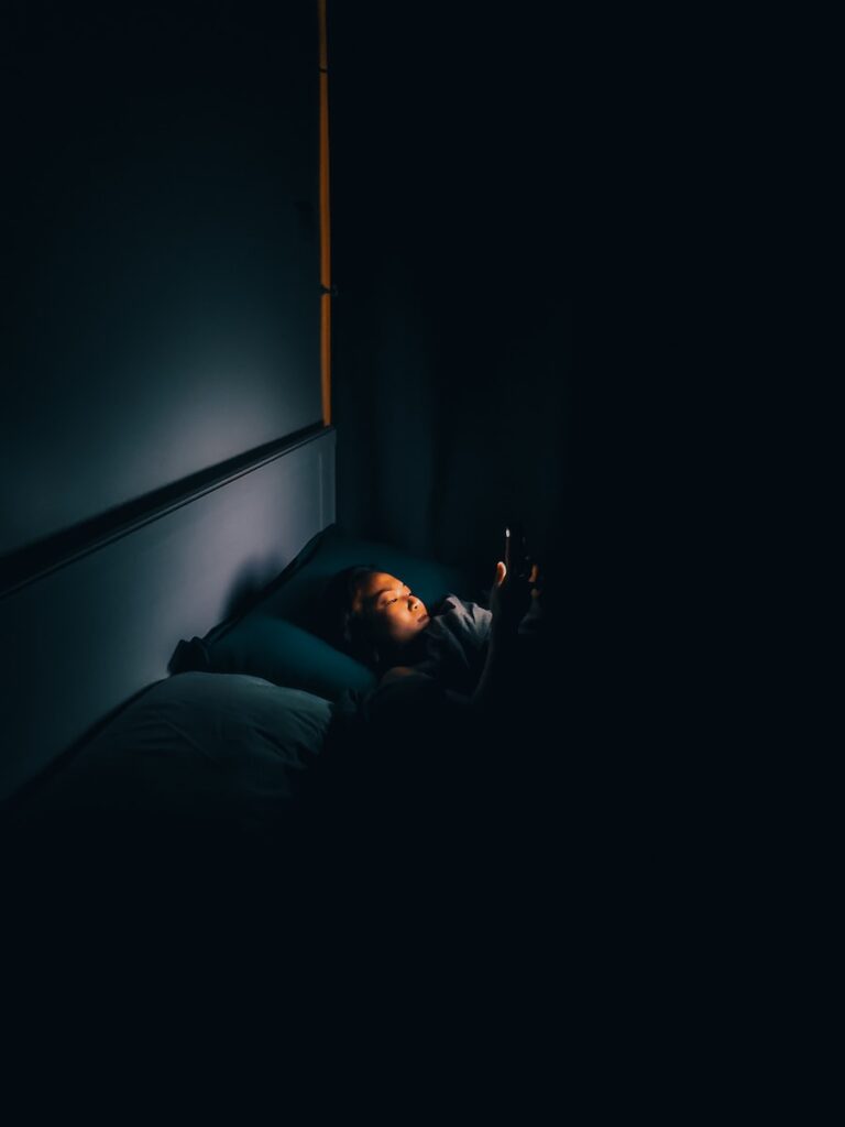man in black jacket lying on bed